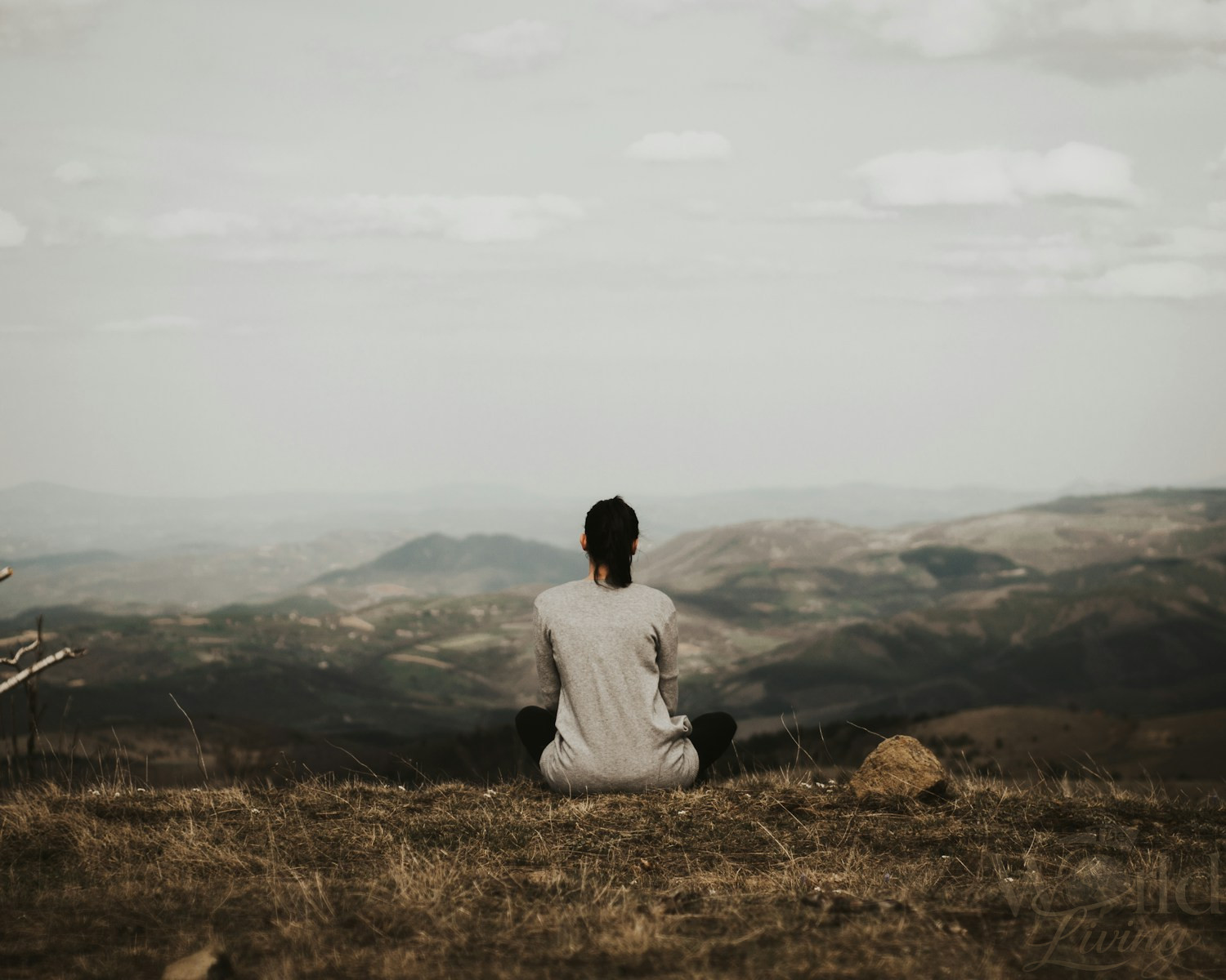 The Most Inspiring Travel Experiences Around the World 3 woman sitting on cliff overlooking mountains during daytime