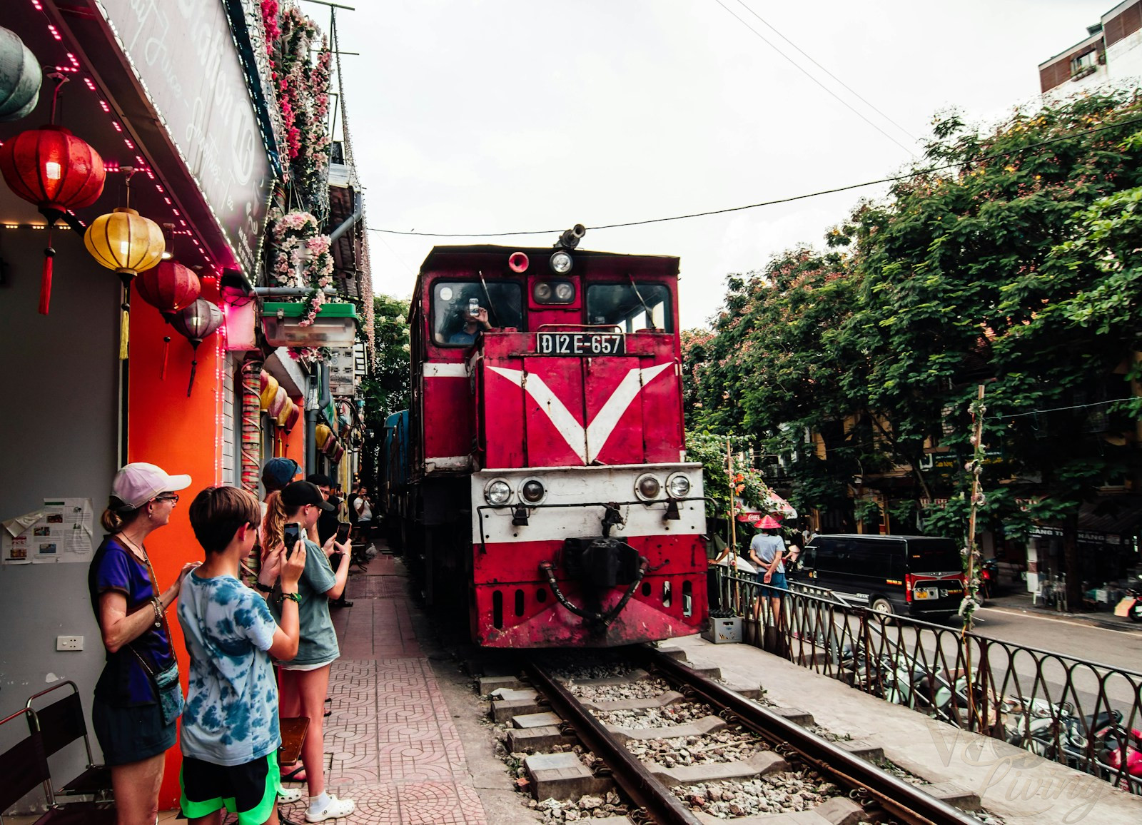 How Much It Really Costs to Travel Asia in 2026 2 How Much It Really Costs to Travel Asia. A red train traveling down train tracks next to a crowd of people.